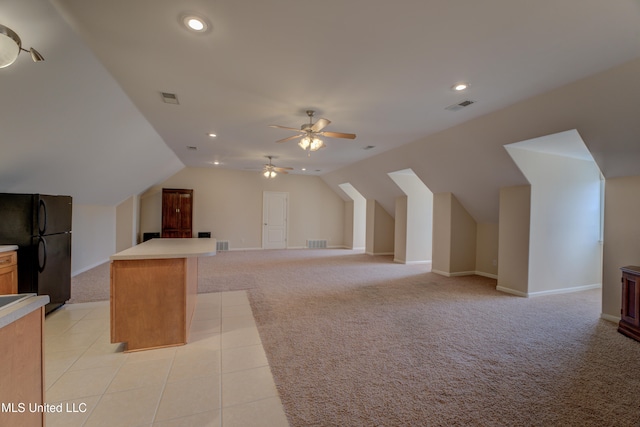 additional living space featuring ceiling fan, light carpet, and vaulted ceiling