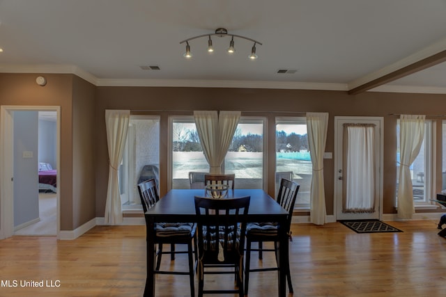 dining area featuring ornamental molding and light wood-type flooring