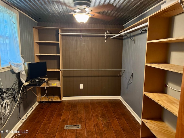 walk in closet with ceiling fan and dark hardwood / wood-style flooring