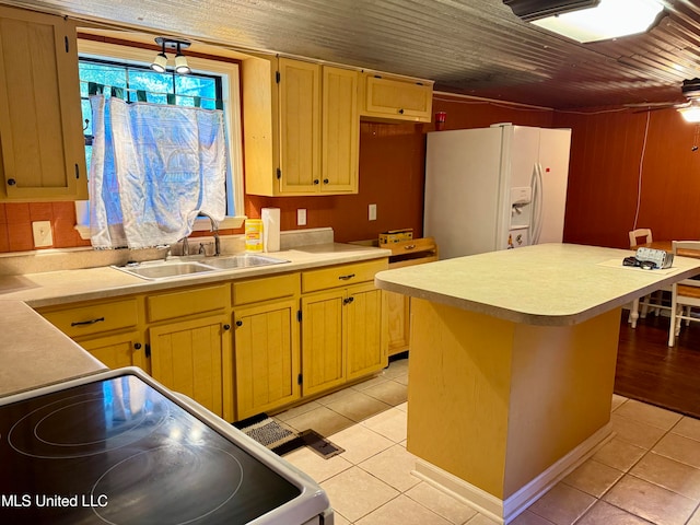 kitchen featuring white fridge with ice dispenser, light tile patterned floors, stove, and sink