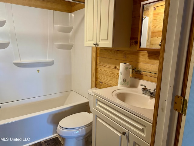 full bathroom featuring bathtub / shower combination, vanity, hardwood / wood-style flooring, toilet, and wood walls