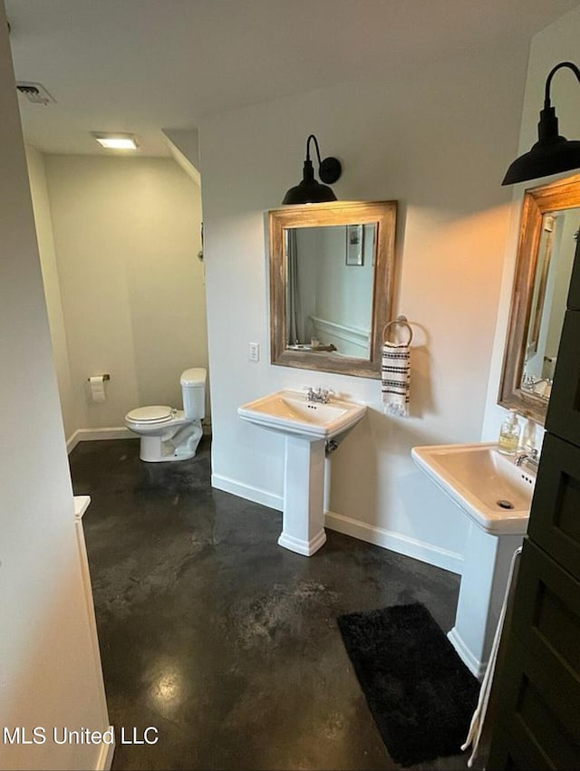 bathroom with visible vents, baseboards, toilet, and concrete floors