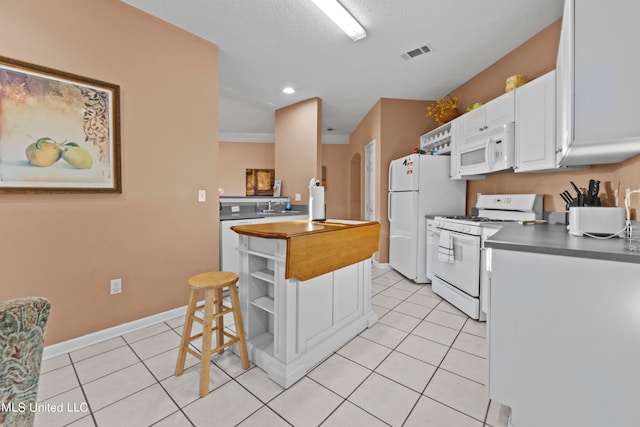 kitchen featuring sink, crown molding, light tile patterned floors, white cabinetry, and white appliances