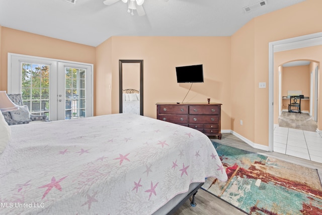 bedroom featuring french doors, access to outside, vaulted ceiling, light hardwood / wood-style floors, and ceiling fan