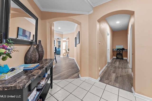 hallway featuring crown molding and light hardwood / wood-style flooring