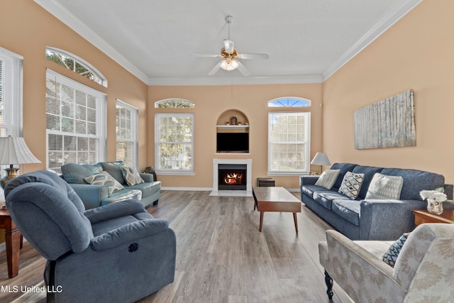 living room with light wood-type flooring, ornamental molding, and plenty of natural light