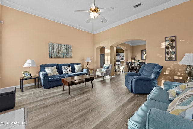 living room featuring ceiling fan, ornamental molding, and hardwood / wood-style floors