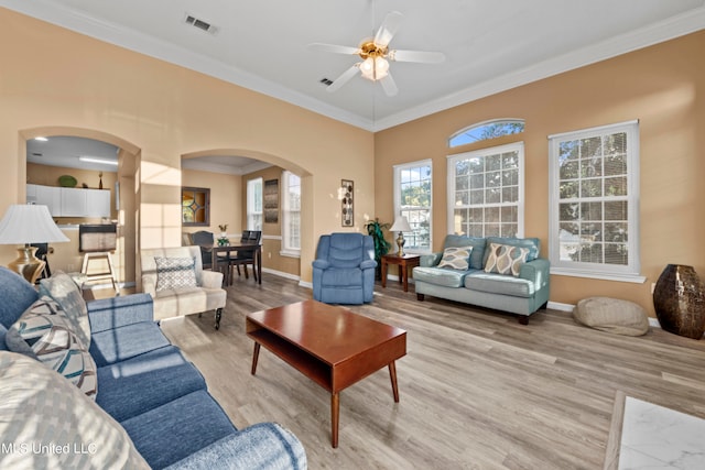 living room featuring crown molding, light hardwood / wood-style flooring, and ceiling fan