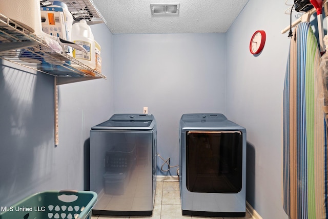 639 Plantation Way, Byhalia, MS 38611 - washroom with independent washer and dryer, a textured ceiling, and light tile patterned flooring