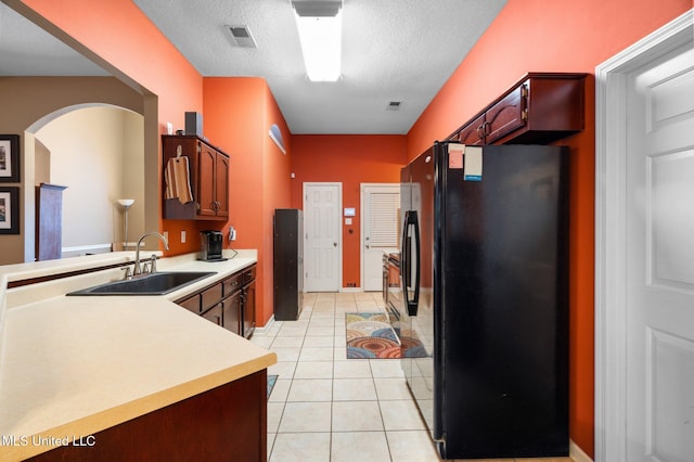 639 Plantation Way, Byhalia, MS 38611 - kitchen with freestanding refrigerator, arched walkways, a sink, light countertops, and a textured ceiling