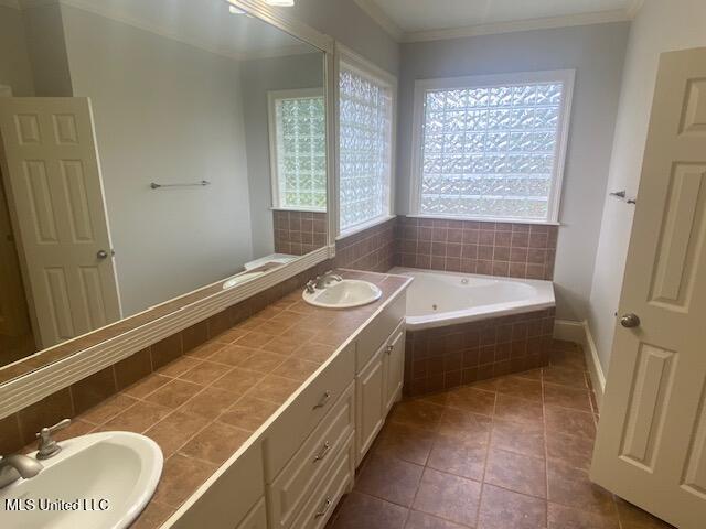 309 Barrington Cv, Byram, MS 39272 - full bathroom featuring a whirlpool tub, double vanity, ornamental molding, and tile patterned floors