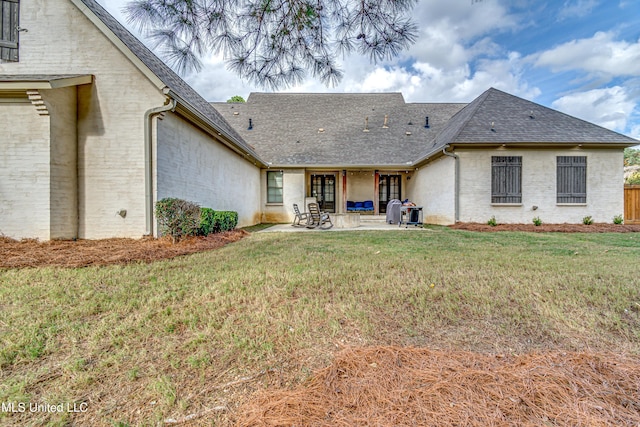 back of property featuring a yard and a patio