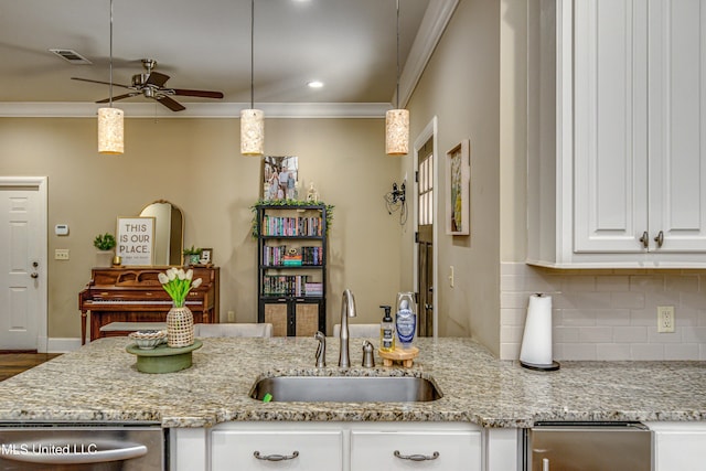 kitchen featuring white cabinets, light stone counters, ceiling fan, and sink