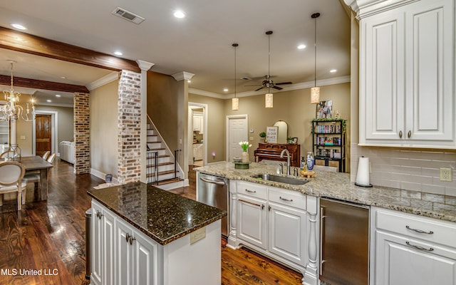 kitchen featuring ceiling fan with notable chandelier, sink, pendant lighting, a center island, and dark hardwood / wood-style floors