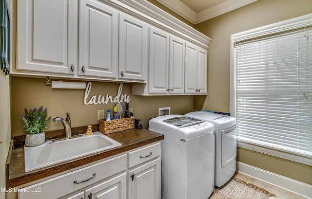 clothes washing area featuring separate washer and dryer, sink, light tile patterned floors, and cabinets