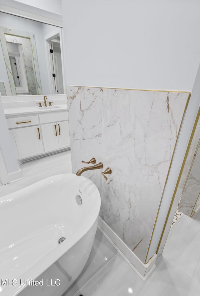 135 Genoa Dr, Madison, MS 39110 - full bath featuring a freestanding bath, vanity, marble finish floors, tile walls, and a wainscoted wall