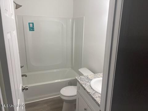 full bathroom featuring  shower combination, vanity, wood-type flooring, and toilet