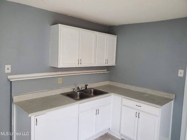 2067 Corry Rd, Memphis, TN 38106 - kitchen with a sink, white cabinetry, and light countertops