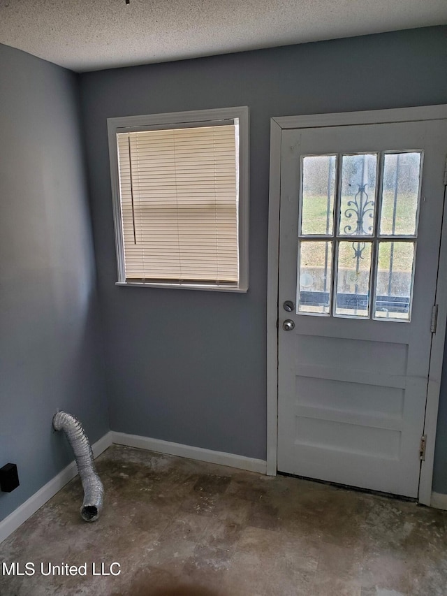 2067 Corry Rd, Memphis, TN 38106 - doorway with concrete floors, a textured ceiling, and baseboards