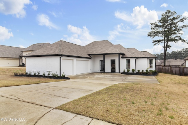 view of front facade featuring a garage, concrete driveway, a front yard, and fence