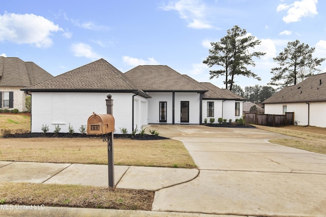 view of front of home featuring a front yard and roof with shingles