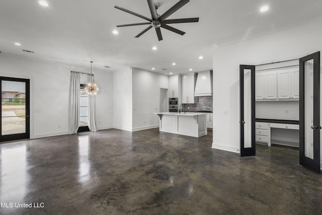 unfurnished living room with baseboards, a ceiling fan, finished concrete floors, a sink, and recessed lighting