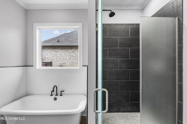 bathroom featuring a freestanding bath, ornamental molding, a stall shower, and tile walls