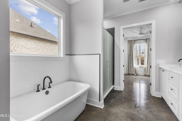 full bathroom featuring visible vents, finished concrete floors, vanity, a freestanding tub, and tile walls