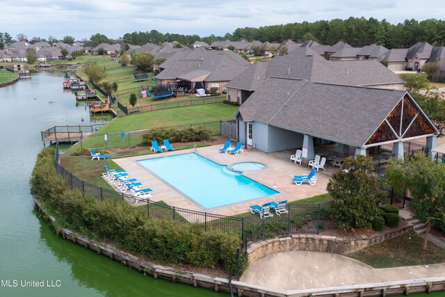 pool featuring a patio, a water view, a fenced backyard, and a residential view