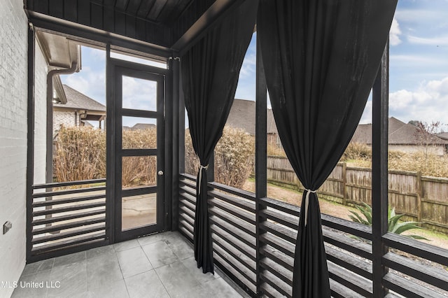 doorway to outside featuring brick wall and tile patterned floors