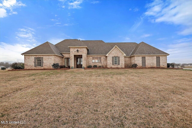 french country style house featuring a front yard