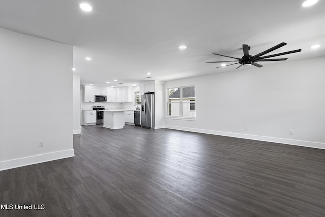 unfurnished living room featuring recessed lighting, a ceiling fan, dark wood-type flooring, and baseboards