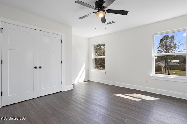 unfurnished bedroom with visible vents, baseboards, dark wood finished floors, a closet, and a ceiling fan