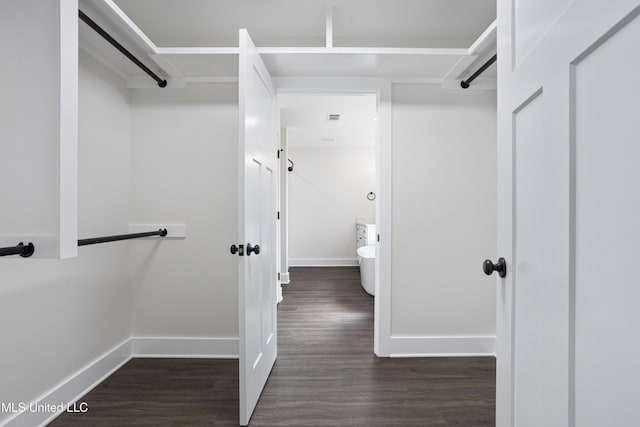 walk in closet featuring dark wood finished floors