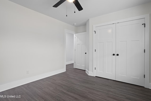 unfurnished bedroom with a closet, a ceiling fan, baseboards, and dark wood-style flooring