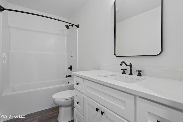 bathroom featuring toilet, tub / shower combination, vanity, and wood finished floors