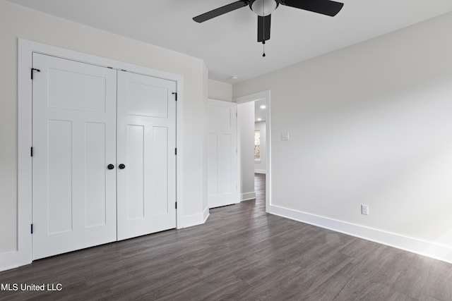 unfurnished bedroom with dark wood finished floors, a ceiling fan, baseboards, and a closet