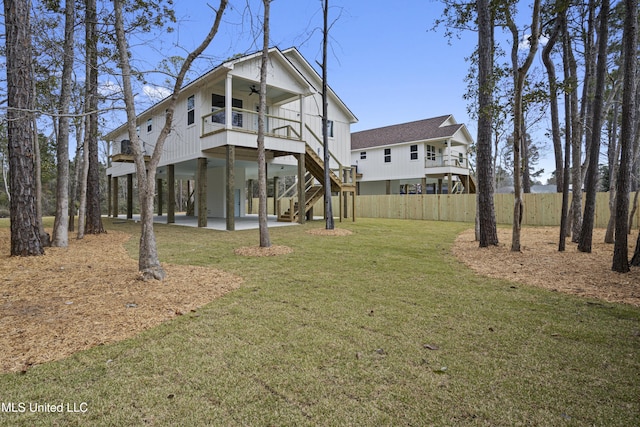 back of house with a lawn, fence, a carport, ceiling fan, and stairs