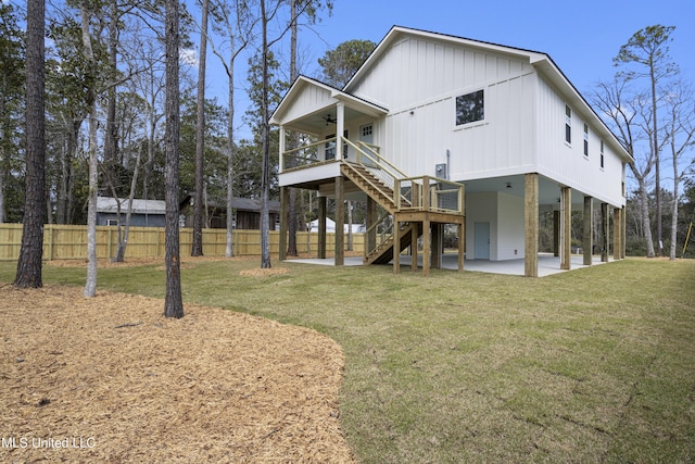 back of property featuring a ceiling fan, a patio, fence, a yard, and stairs