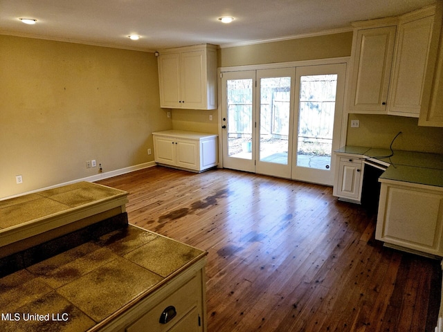 kitchen with white cabinetry, ornamental molding, and dark wood-type flooring