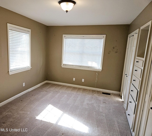 unfurnished bedroom featuring light carpet