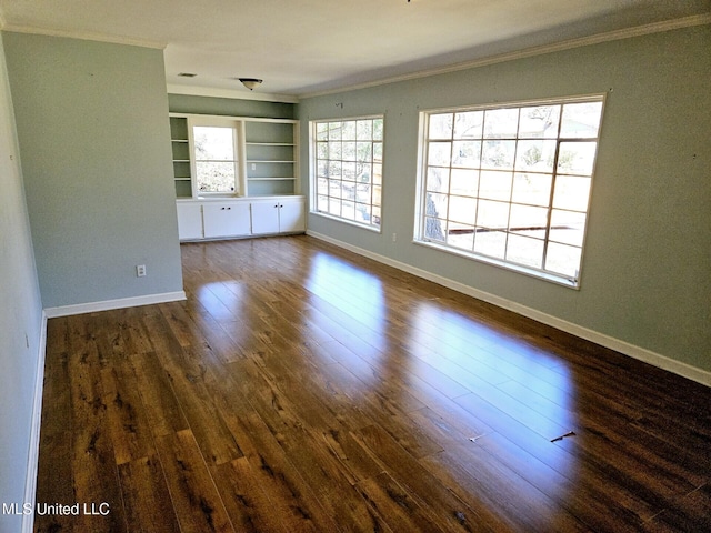 spare room with crown molding, dark hardwood / wood-style floors, and built in shelves