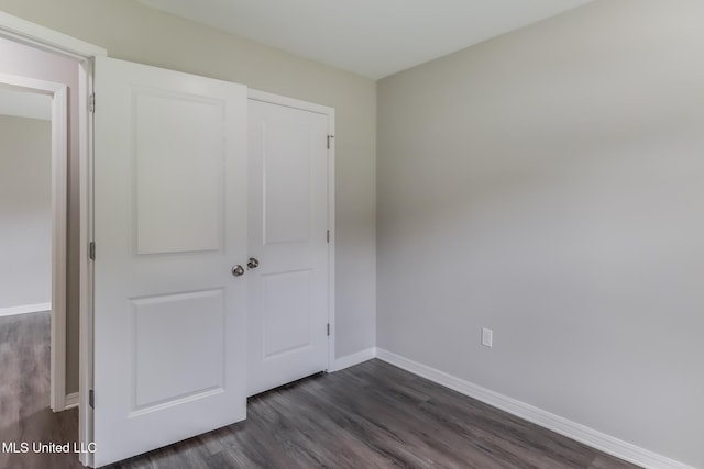 13262 Turtle Creek Pkwy, Gulfport, MS 39503 - unfurnished bedroom featuring dark wood-type flooring and baseboards