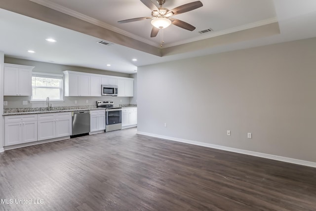 13262 Turtle Creek Pkwy, Gulfport, MS 39503 - kitchen with stainless steel appliances, dark wood-style flooring, baseboards, recessed lighting, and a raised ceiling