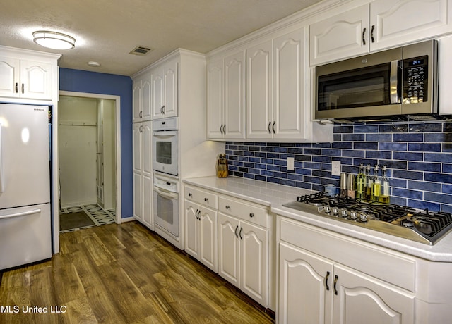 911 Newitt Vick Dr, Vicksburg, MS 39183 - kitchen featuring stainless steel appliances, white cabinetry, light countertops, and decorative backsplash