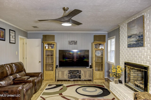 911 Newitt Vick Dr, Vicksburg, MS 39183 - living area featuring light wood-type flooring, crown molding, a ceiling fan, a brick fireplace, and a textured ceiling