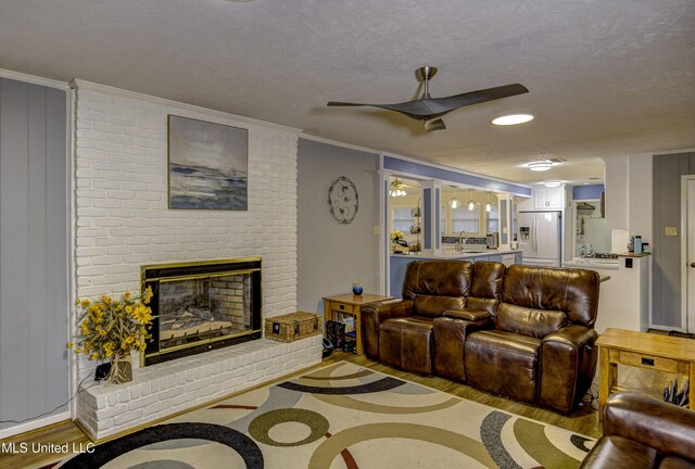 911 Newitt Vick Dr, Vicksburg, MS 39183 - living area featuring crown molding, wood finished floors, a brick fireplace, ceiling fan, and inlaid floor details