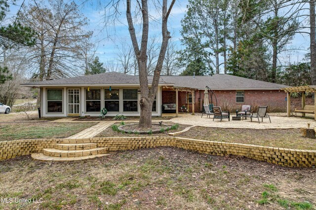 911 Newitt Vick Dr, Vicksburg, MS 39183 - back of house featuring an outdoor fire pit, a patio area, and brick siding
