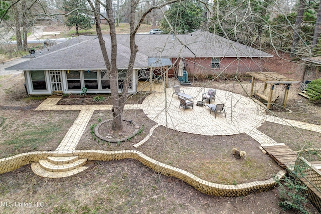 911 Newitt Vick Dr, Vicksburg, MS 39183 - back of property featuring a patio, a shingled roof, and an outdoor hangout area