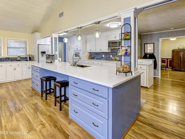 911 Newitt Vick Dr, Vicksburg, MS 39183 - kitchen with a sink, appliances with stainless steel finishes, white cabinetry, backsplash, and lofted ceiling